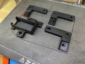 Another tray of parts is freshly printed in black PLA. I will need to make eight batches of these.