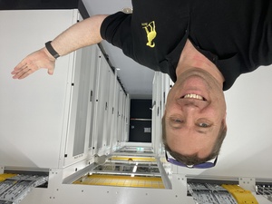 A selfie of me in the new cage with 14 racks that will be taken into service over the next few weeks. First order of business: get the IT and telecom equipment installed and configured.