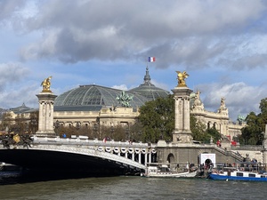 A picture of Grand Palais with the beautiful Pont Alexandre III bridge over river Seine in the foreground
