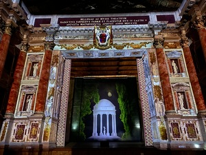 An overview of the stage area, lit by projector screens to resemble what it once looked like, in Teatro Farnese, Parma, Italy