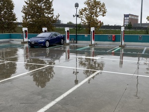 Our car is all alone on the Tesla Supercharger, but it's still raining also. Bah.